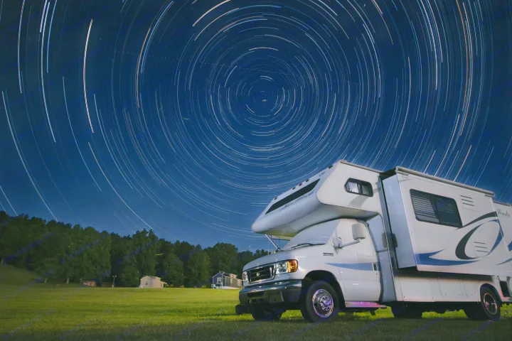 Experience cosmic camping with an RV rental! A motorhome is parked under stunning star trails in a long-exposure night sky.. Four Winds 5000 2008