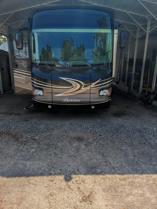 Berkshire motorhome for RV rental, front view. Parked under a shelter on a gravel lot.. Forest River Berkshire 2018