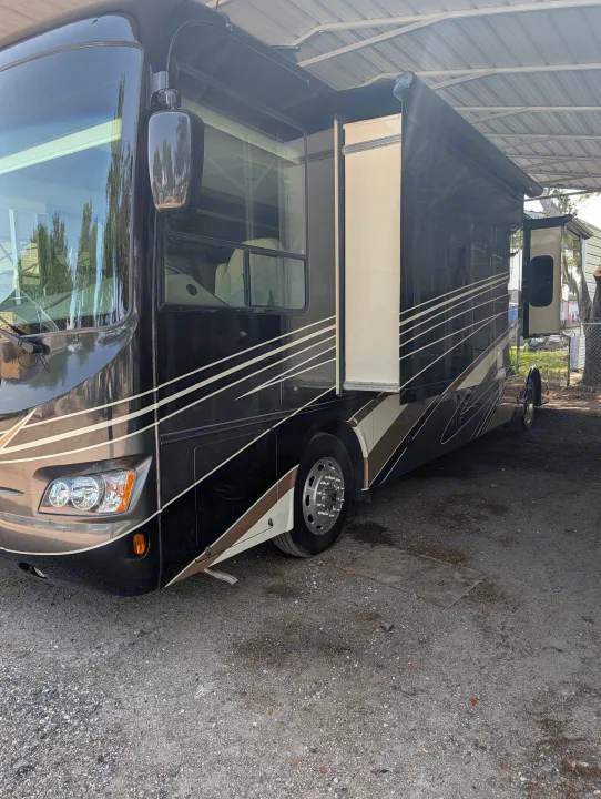 Luxury dark RV rental with extended slide-outs parked under a carport, perfect for your next road trip adventure.. Forest River Berkshire 2018