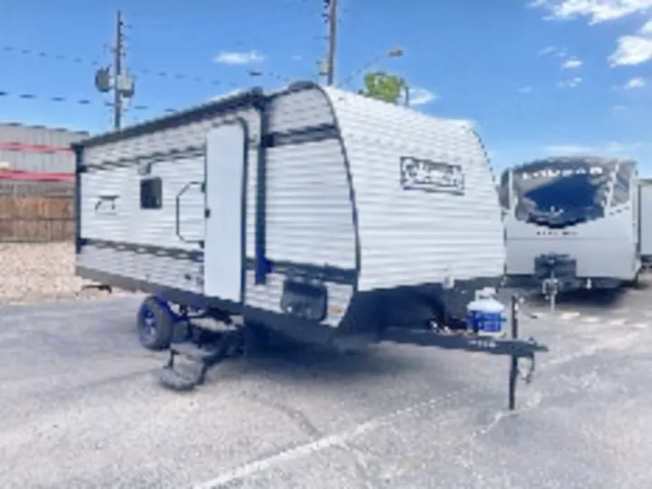 This grey Coleman travel trailer is an excellent RV rental for camping adventures. Parked outdoors, with an extended awning.. Keystone Coleman 19B 2026