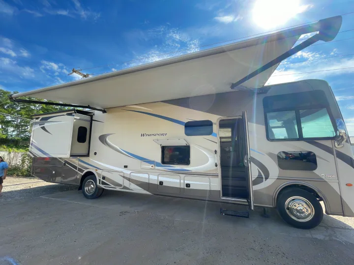 Thor Windsport motorhome with extended awning and slide-out, parked under a bright sky. Perfect for your next rv rental.. Thor Windsport 2019