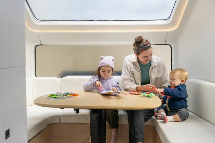 Inside a modern rv rental: a family enjoys crafting and playing. A comfortable space for family travel adventures.. Pebble Flow 2026