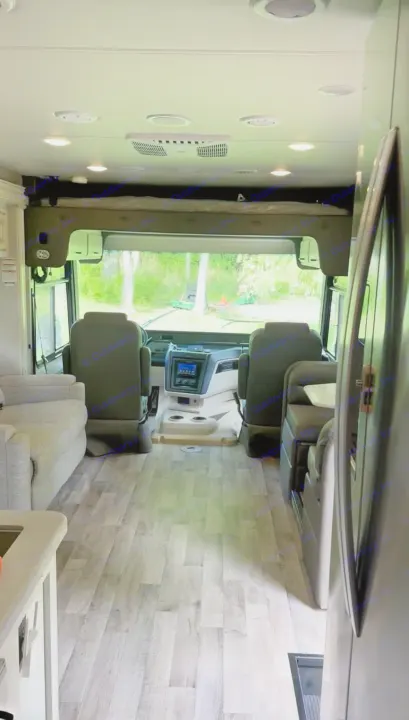 Looking forward in this RV rental, the driver's area is ahead, with a lounge left, dinette right, and an overhead bunk.. Jayco Precept 2022
