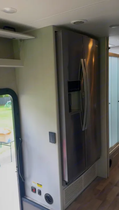 RV rental interior: sleek French door refrigerator with dispenser, wall controls, and open overhead cabinet.. Jayco Precept 2022