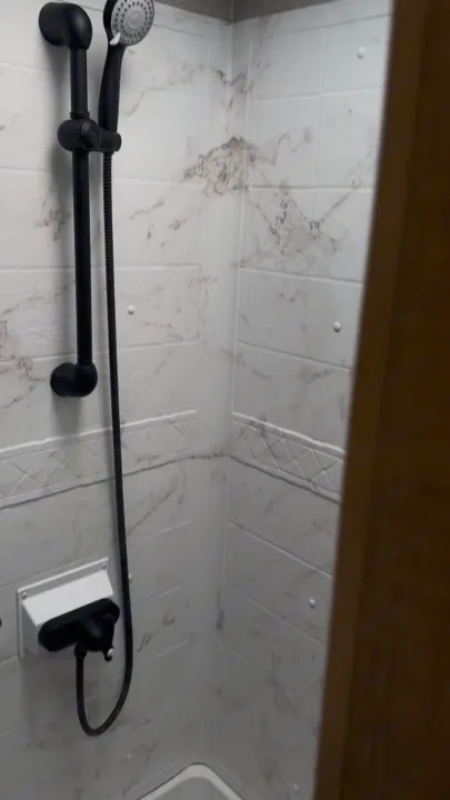 Compact shower with modern black fixtures and marble-look tiles in this RV rental. Perfect for travel adventures.. Jayco Precept 2022