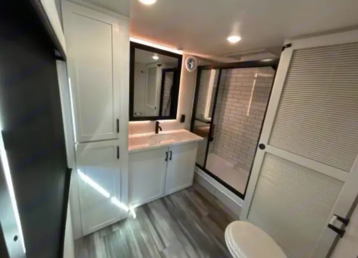 Modern RV rental bathroom featuring a white vanity, black-framed mirror & shower, subway tile, and toilet.. Jayco Jay Flight Bungalow 2025