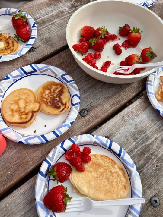 RV rental breakfast: Pancakes, fresh strawberries & raspberries on a wooden picnic table. Enjoying nature's feast!. Keystone RV Cougar 2018