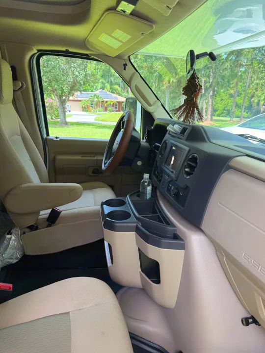 RV rental: Spacious interior of a Ford E-Series van, showing the driver's area, dashboard, and central console.. Thor Chateau 2025