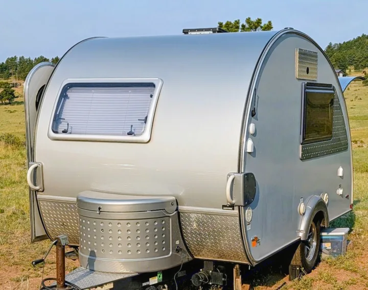 A sleek silver teardrop RV rental, parked outdoors. Ideal for a cozy camping or road trip adventure.. nuCamp T@B CS-S 2017