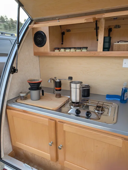 This RV rental's teardrop trailer galley kitchen features a stove, sink, and coffee setup for convenient outdoor cooking.. nuCamp T@B CS-S 2017