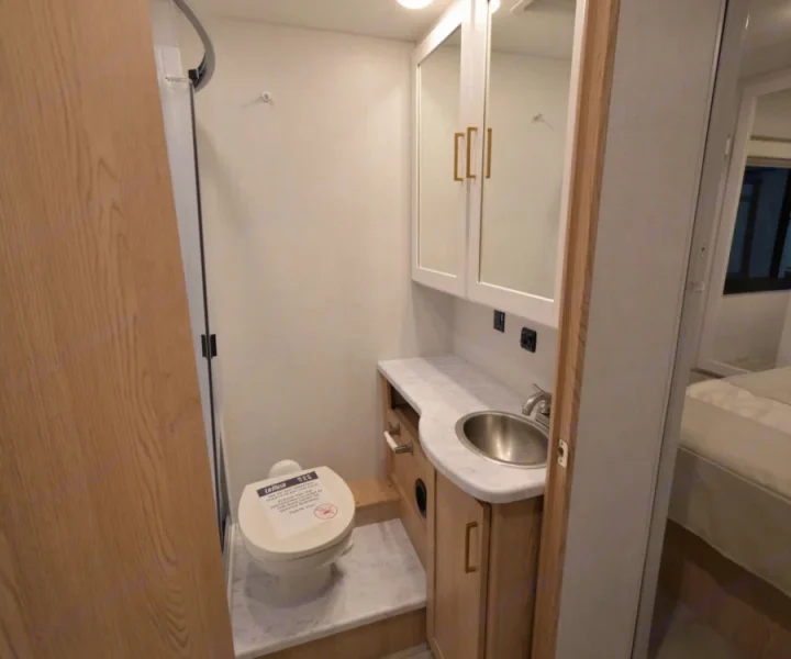 This compact RV rental bathroom features a toilet, sink, and mirror cabinet, maximizing space for travelers.. Thor Chateau 2026