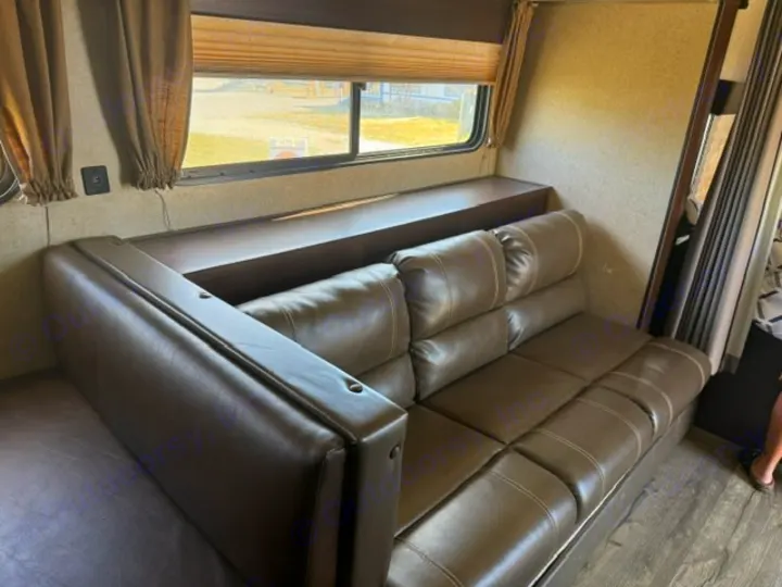 RV rental interior: a brown L-shaped sofa with a window and wood-look floor, ideal for relaxing in your mobile home.. Forest River Cherokee Wolf Pup 2018
