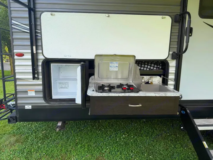 This RV rental features a convenient outdoor kitchen with a fridge, two-burner stove, and sink, perfect for camping meals.. Jayco Jay Flight 2021