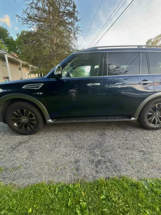 Dark blue SUV by grass & trees. A reliable ride for trips; explore our full range, including rv rental options.. Nissan 2017 Nissan Armada Platinum 4WD V8 2017