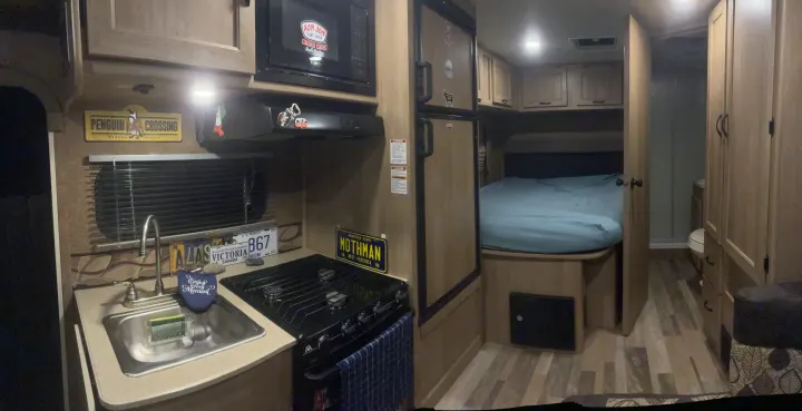Cozy RV rental interior featuring a compact kitchen, comfortable bedroom, and attached bathroom for convenient travel.. Forest River Coachmen Freelander 2015
