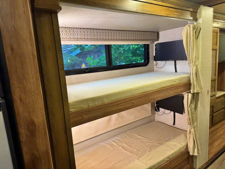 RV rental bunk beds with personal TVs, window views, and privacy curtains, perfect for travel.. Jayco Precept 2019