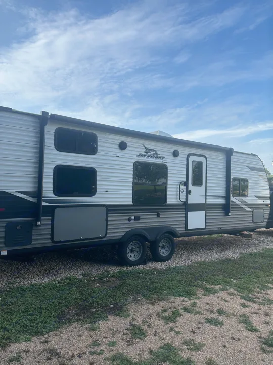 Jayco Jay Flight RV rental parked on gravel under a blue sky, ready for adventure.. Jayco Jay Flight 2023