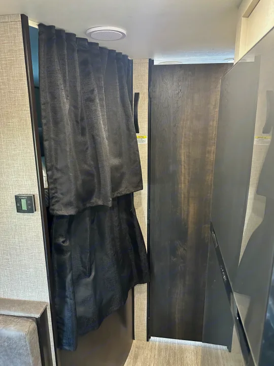 Experience privacy in this RV rental with a dark pull-out curtain for the sleeping area, featuring a Dometic climate control.. Jayco Jay Flight 2023