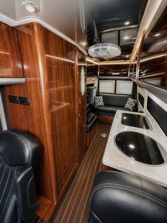 Step inside this premium RV rental: sleek wood interior, modern kitchenette, comfy lounge. Ideal for luxury travel.. Airstream Interstate 2017