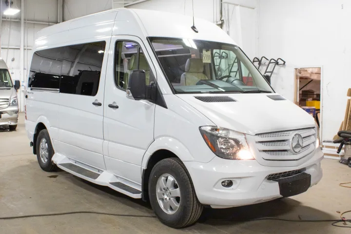 White Mercedes-Benz Sprinter conversion van for rv rental, with tinted windows & running boards, parked indoors.. Mercedes-Benz 4x4 Sprinter mwb 2020