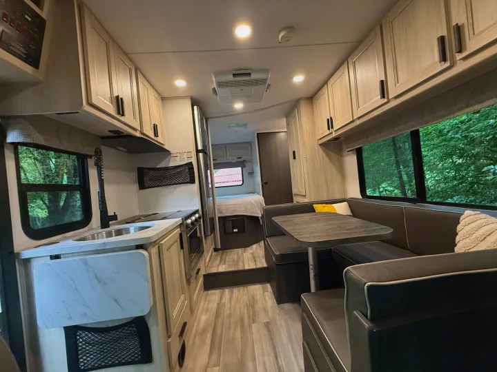 Modern and spacious RV rental interior, featuring a bright kitchen, cozy dinette, and comfortable bed area for your next adventure.. Forest River Sunseeker LE 2023