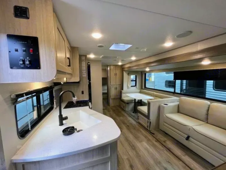 Modern RV rental interior with a spacious kitchen, dinette, and living area, perfect for your next adventure.. Forest River Catalina Coachmen Legacy 293QBCKLE 2026