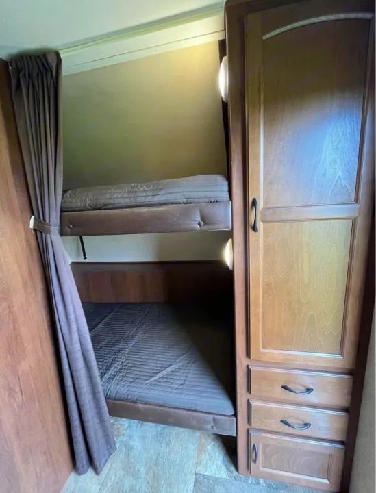 RV rental interior: bunk beds with mattresses, privacy curtains, and a convenient wardrobe. Ideal for families.. Jayco Jay Feather Ultra Lite 2015