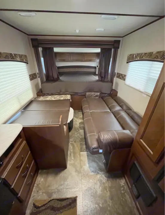 Inside this RV rental, find a comfortable bed, convertible dinette, and reclining sofa, all with warm wood tones.. Jayco Jay Feather Ultra Lite 2015