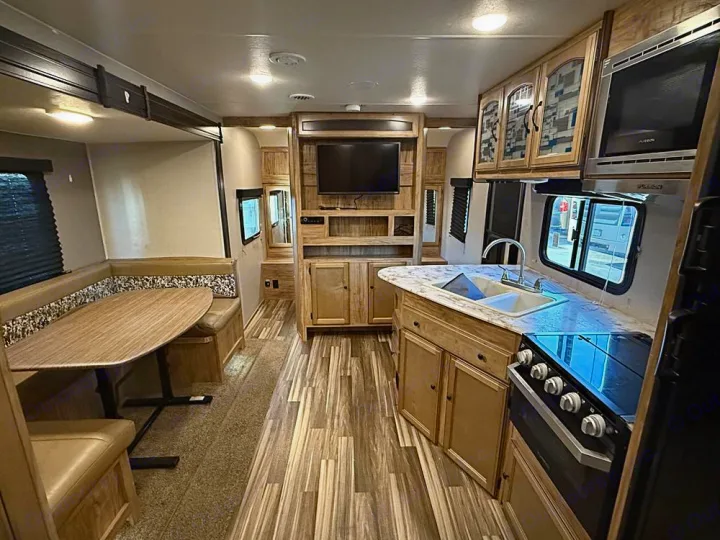 Experience comfort in this rv rental. Interior features a full kitchen with stove, sink, microwave, and a U-shaped dinette.. Coachmen Freedom Express 25SE 2019