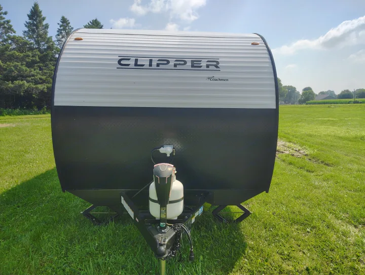 Front view of a Coachmen Clipper travel trailer, ideal for your next RV rental. Parked in a sunny grassy field.. Coachmen Clipper 26BH 2024