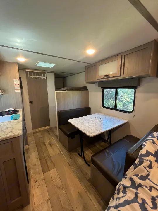 Spacious RV rental interior featuring a kitchen, dinette, bunk beds, and wood-look flooring, ready for adventure.. Coachmen 17b 2024