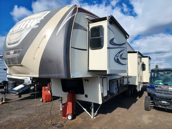 A large Sabre fifth-wheel RV rental with multiple extended slide-outs, parked outdoors. Ideal for camping and travel.. Forest River SABRE 2015