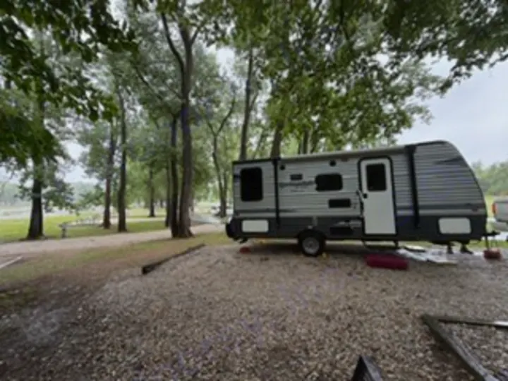 Enjoy nature! This Springdale RV rental travel trailer is set up on a gravel campsite under trees, perfect for a camping getaway.. Keystone RV Springdale Eco-Lite 2018