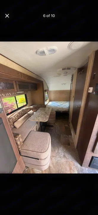 RV rental interior featuring a bright dinette with overhead storage, a cozy bed area, and wood finishes throughout.. Forest River R-Pod 2016