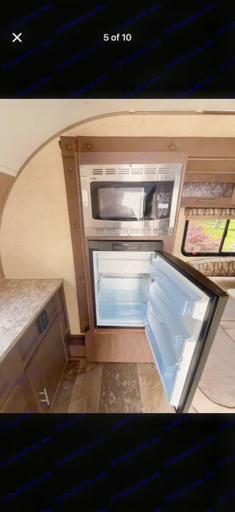 RV rental kitchen: microwave and open Dometic fridge with empty shelves, ready for your next adventure.. Forest River R-Pod 2016