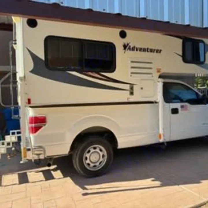A white Adventurer truck camper mounted on a pickup truck, perfect for an RV rental outdoor adventure.. Adventurer/F150 ecoboost 80RB 2018