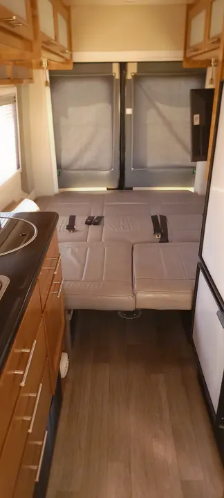 RV rental interior: kitchenette, convertible bed with seatbelts, and rear entry doors with blinds.. Coachmen Crossfit 2019