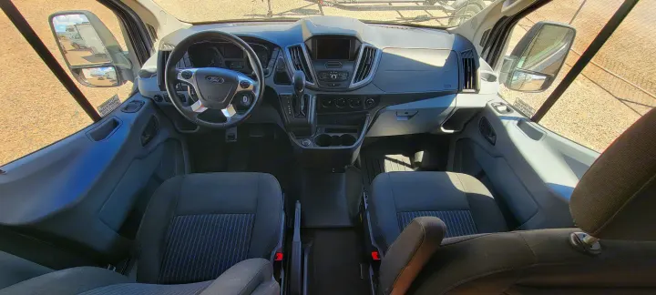 RV rental: Detailed front cabin of a Ford van, showing dashboard, steering wheel, and both gray cloth seats.. Coachmen Crossfit 2019