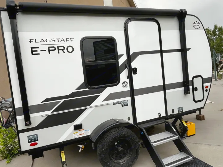A Flagstaff E-Pro travel trailer, an ideal RV rental for adventures, with bold graphics, off-road tires, and sturdy steps.. Forest River Flagstaff E-Pro 2026