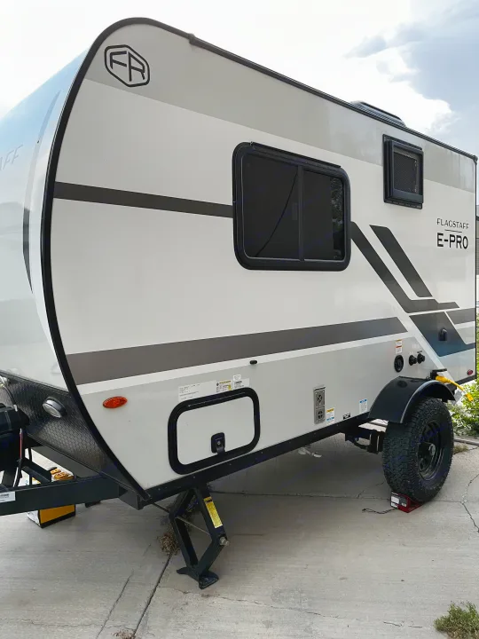 Flagstaff E-Pro travel trailer, a white and grey RV rental parked with stabilizers. Perfect for your outdoor adventure.. Forest River Flagstaff E-Pro 2026