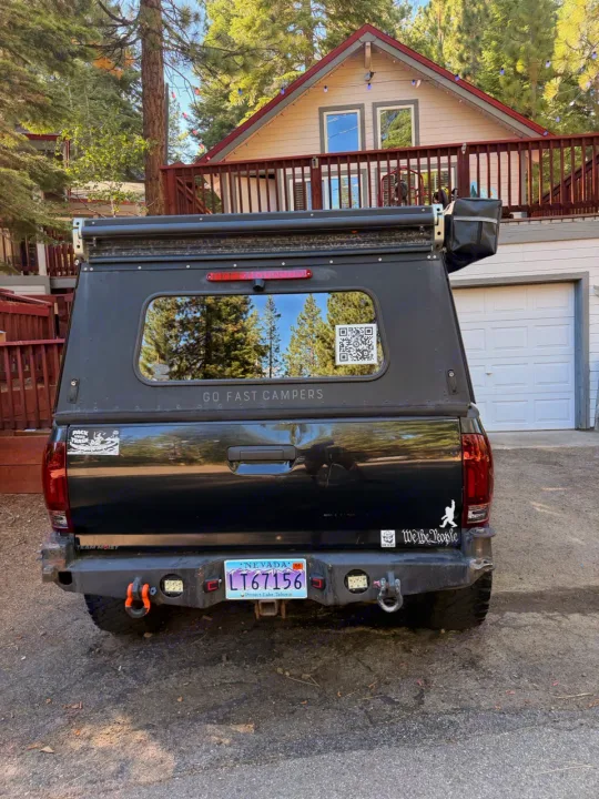 Rugged black truck with Go Fast Campers shell, an alternative to an RV rental, ready for overlanding adventures.. Toyota Tacoma - GoFastCamper 2007