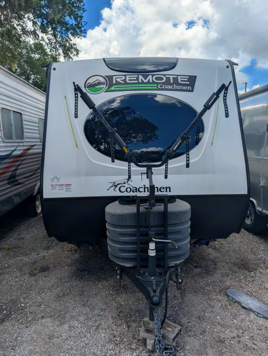 Front view of a white "REMOTE Coachmen" travel trailer, equipped with a bike rack and propane tanks. Ideal for an RV rental.. Coachmen Other 2024