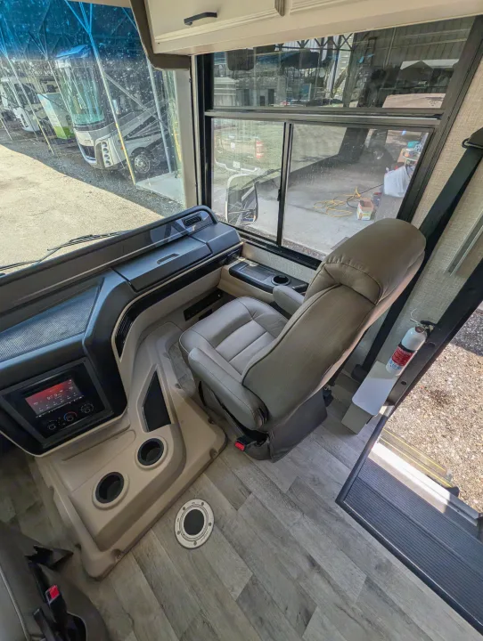 Experience comfort in this RV rental's driver's seat, dashboard, and media system, with a view of other motorhomes.. Entegra Coach Vision XL 2022