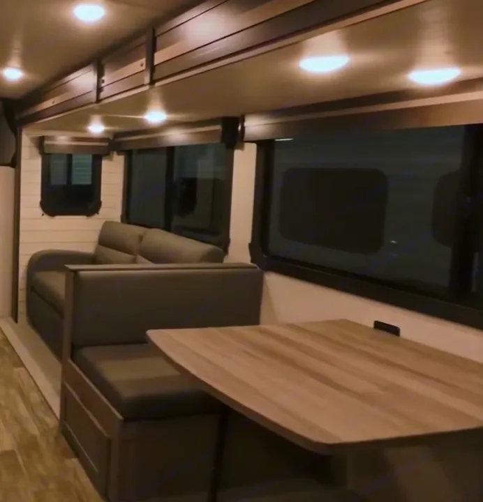 This RV rental's interior features a bright dinette with bench seating and a comfortable sofa, ideal for travel comfort.. Crossroads RV Sunset Trail Super Lite 2022