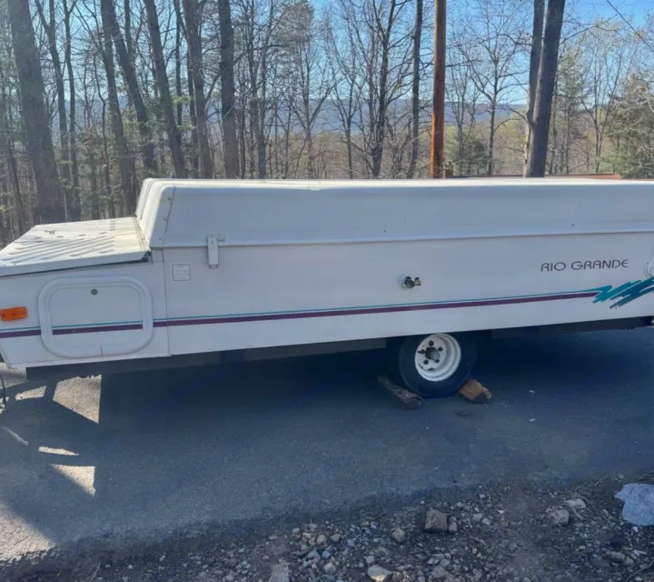 This closed white "Rio Grande" pop-up camper could be an ideal RV rental for a compact outdoor camping adventure.. Coleman Destiny Rio Grande 1995