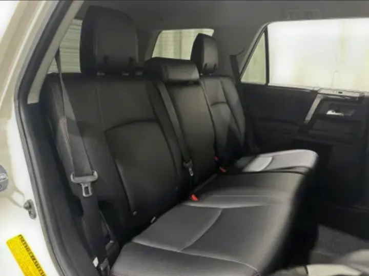 Car's black leather rear seats and interior, seat belts visible. Comfortable and spacious for journeys, ideal with an RV rental.. Toyota 4Runner 2020