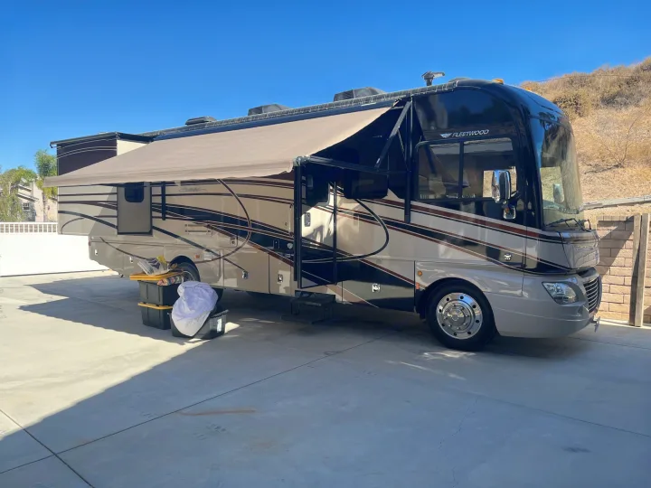 Modern Fleetwood Southwind Class A RV rental parked on a driveway with awning out, ready for your next road trip adventure.. Fleetwood Southwind 2015