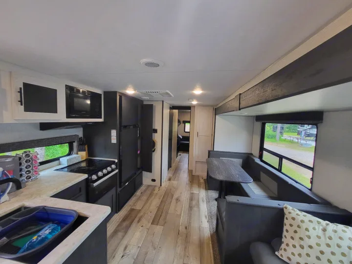 This RV rental interior offers a modern kitchen, comfortable dinette seating, and ample space for travel.. KZ Sportsmen SE 332bkhse 2022