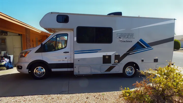 Coachmen Cross Trail RV rental parked in a driveway, ready for adventure and outdoor travel.. Coachmen Ford Transit 2023