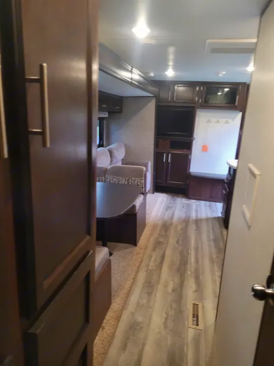 RV rental interior: cozy living space with dining area, TV, and built-in entry bench with coat hooks.. Jayco Jay Flight SLX 2019